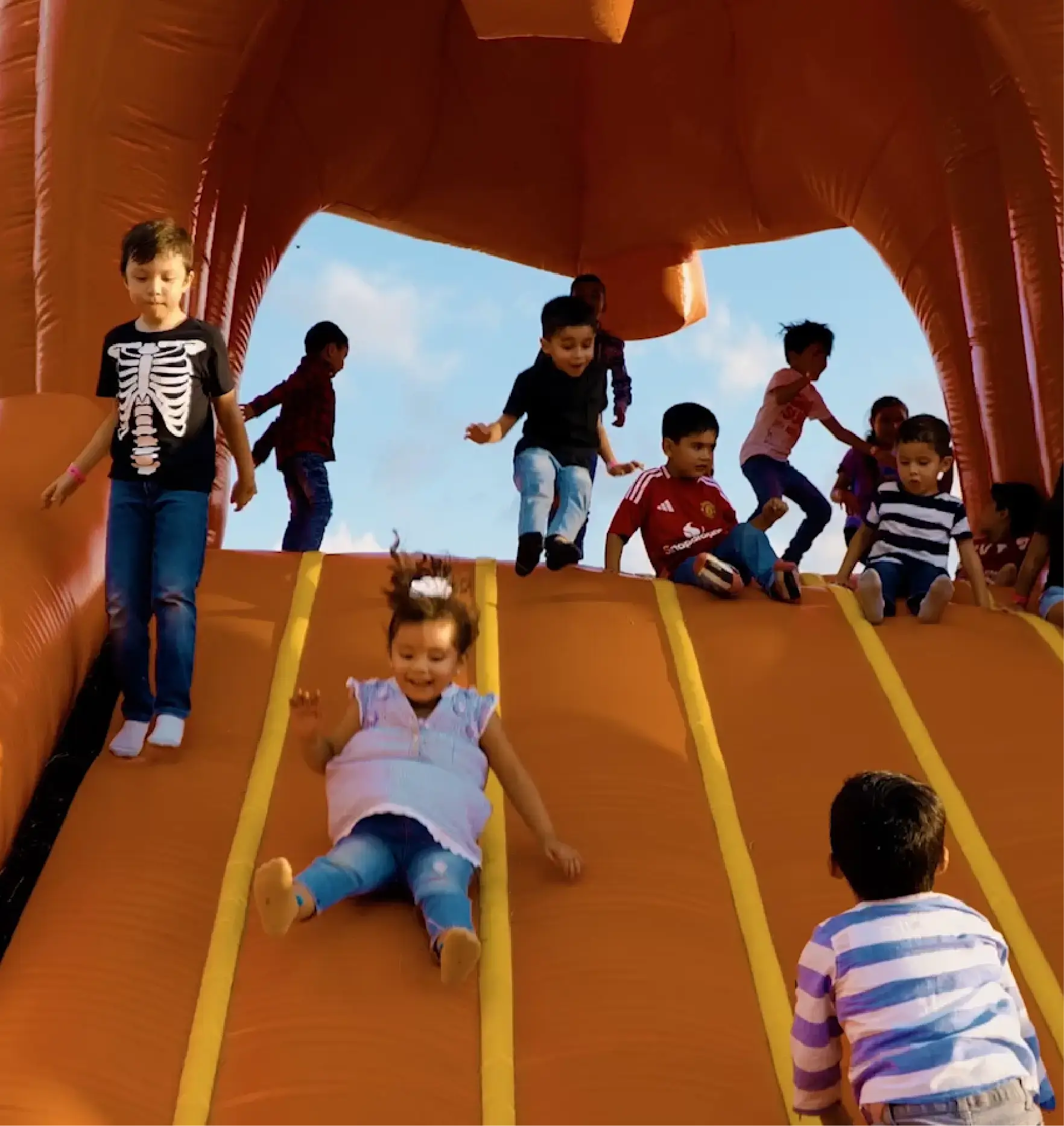 Niños bajan por la resbaladilla gigante